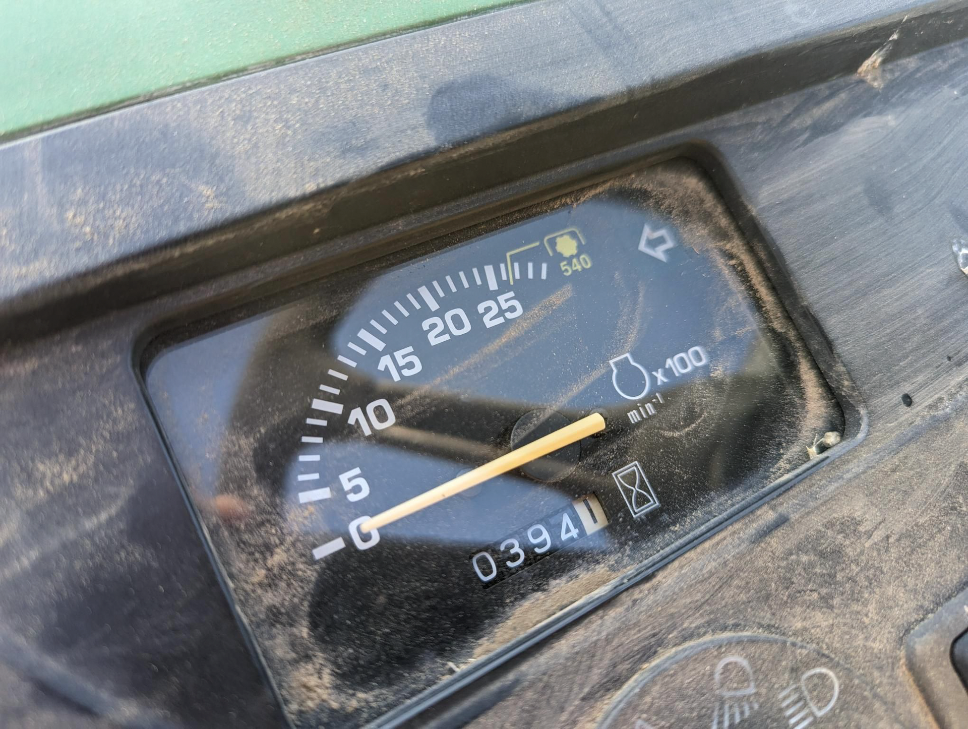 A close up of a speedometer on a green tractor.