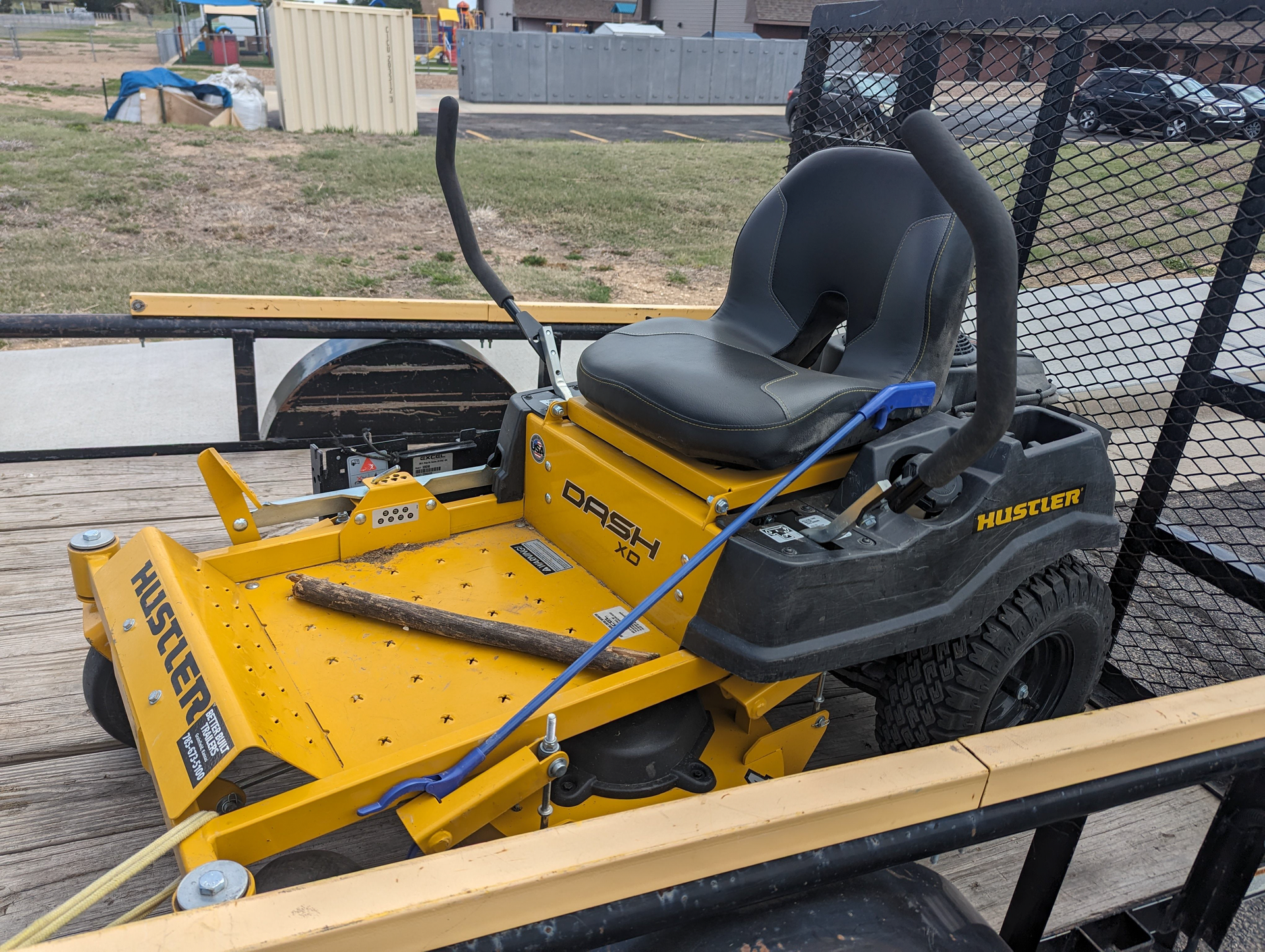 A yellow and black lawn mower is sitting on top of a trailer.
