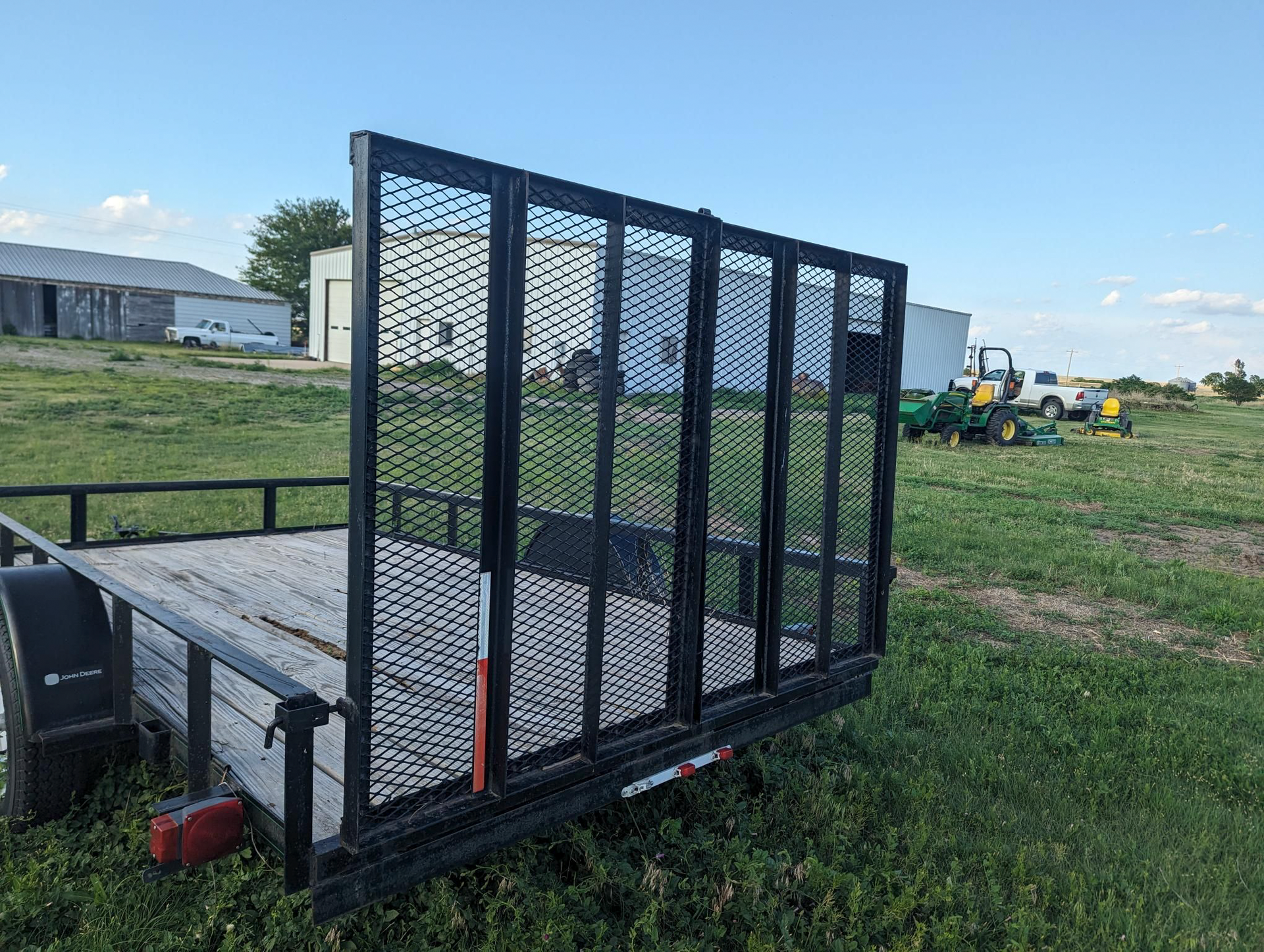 A trailer is parked in the middle of a grassy field.