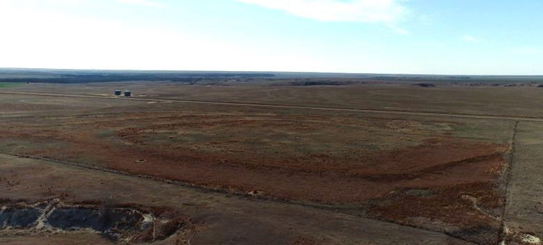 An aerial view of a desert landscape with a blue sky in the background.