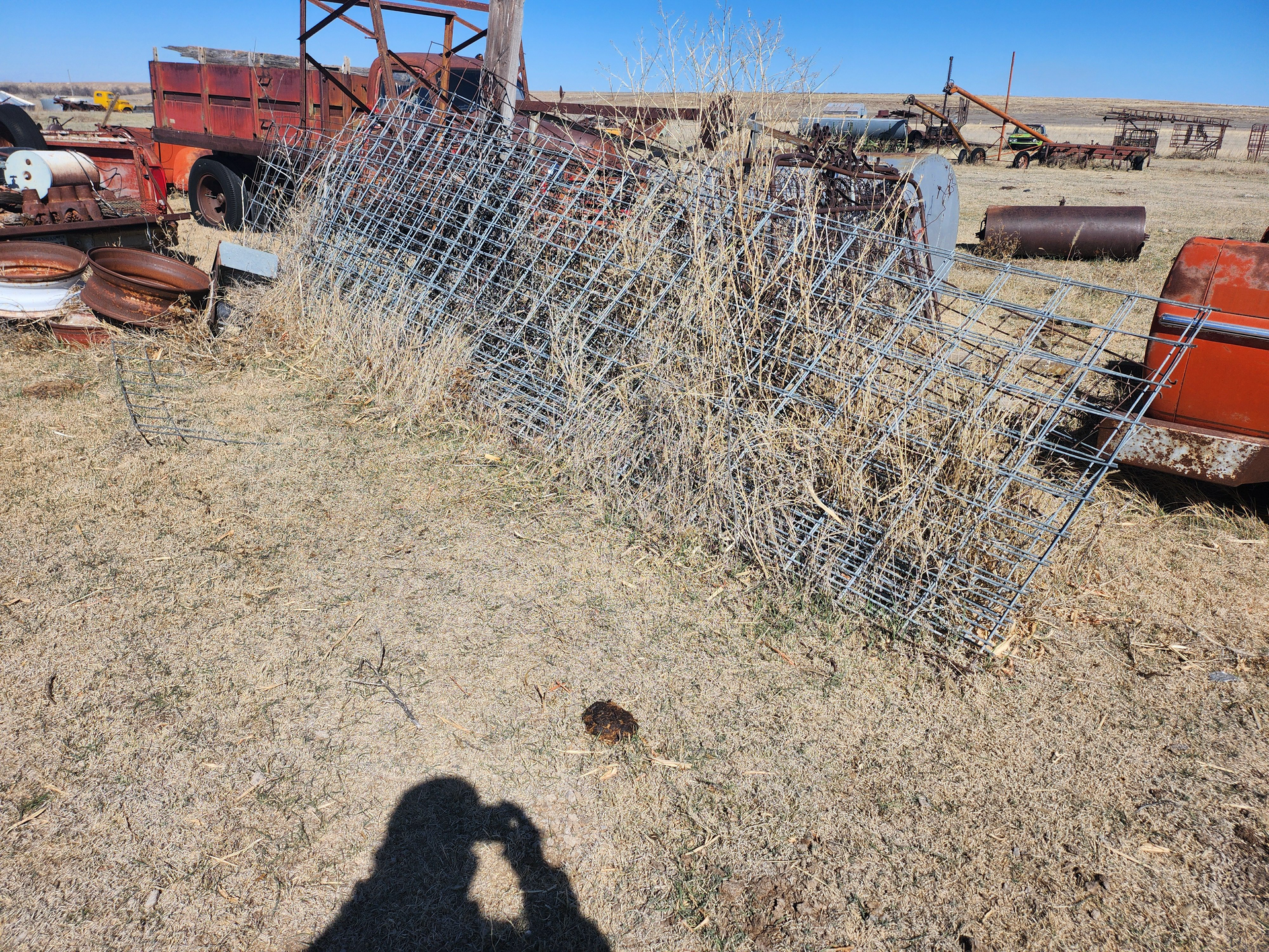 A person is taking a picture of a fence in a field.