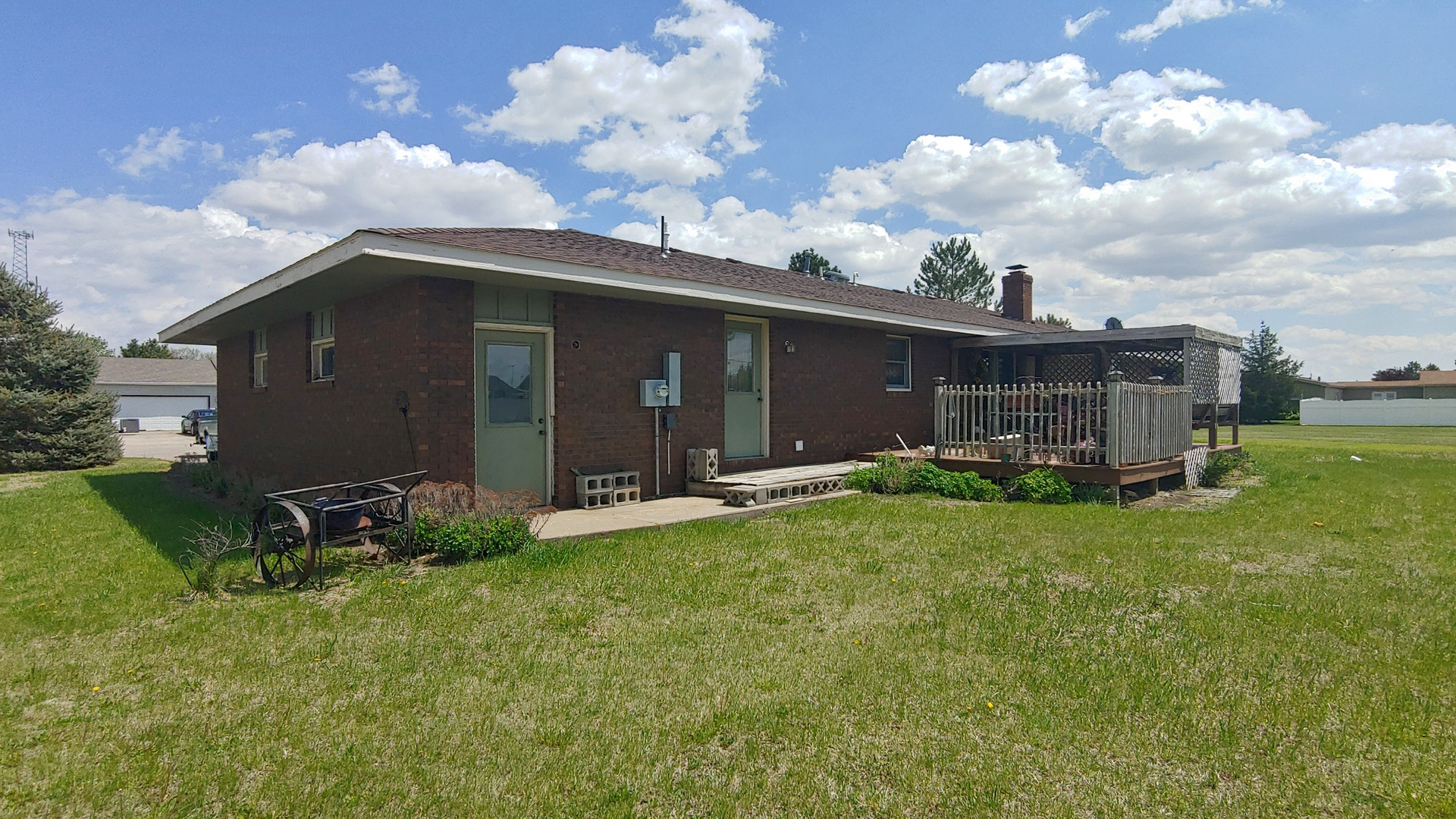 A brick house is sitting in the middle of a grassy field.