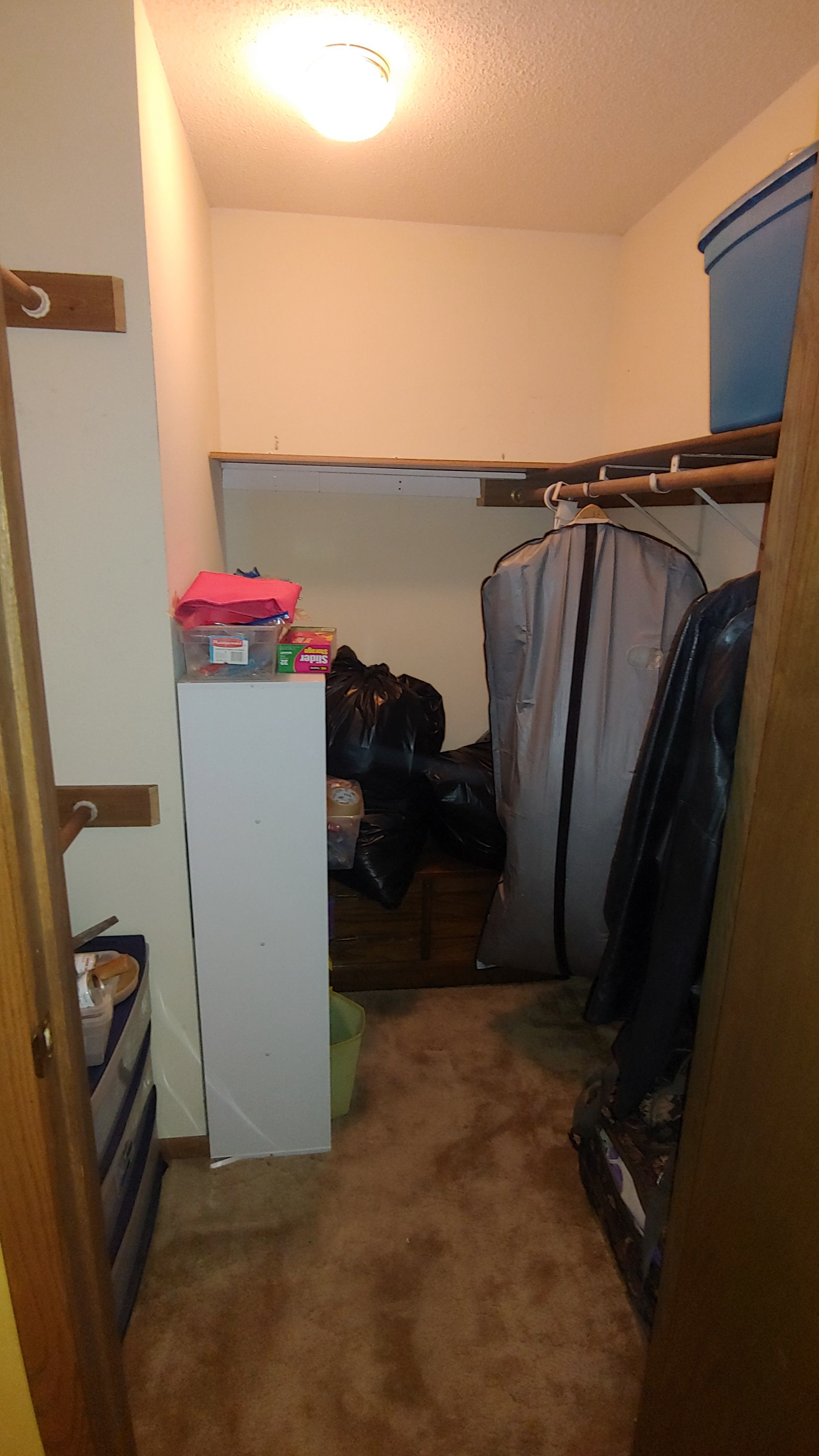 A closet filled with lots of clothes and bags.