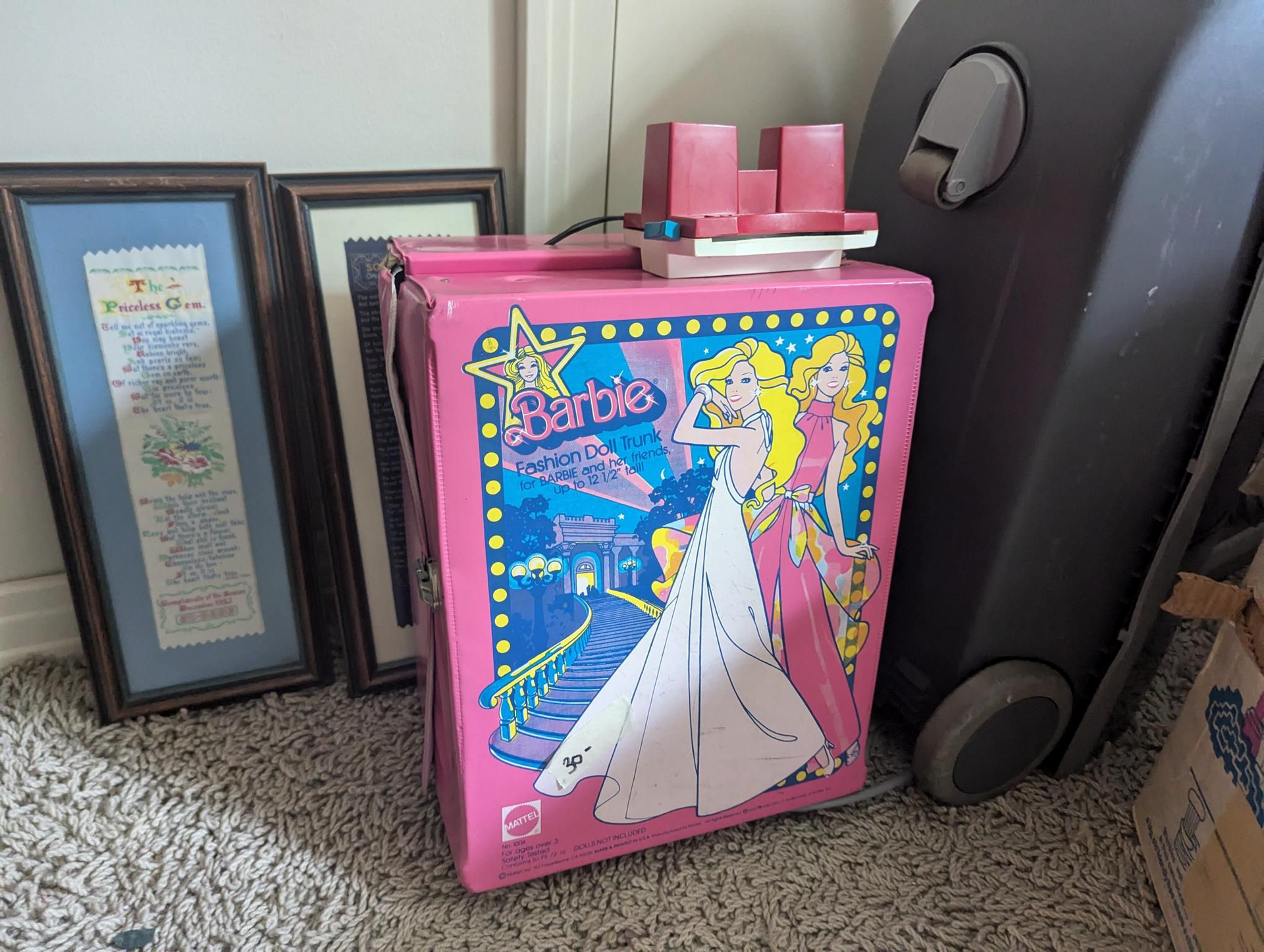 A pink suitcase with a picture of barbie on it