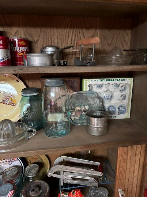 A wooden shelf filled with a variety of kitchen utensils.