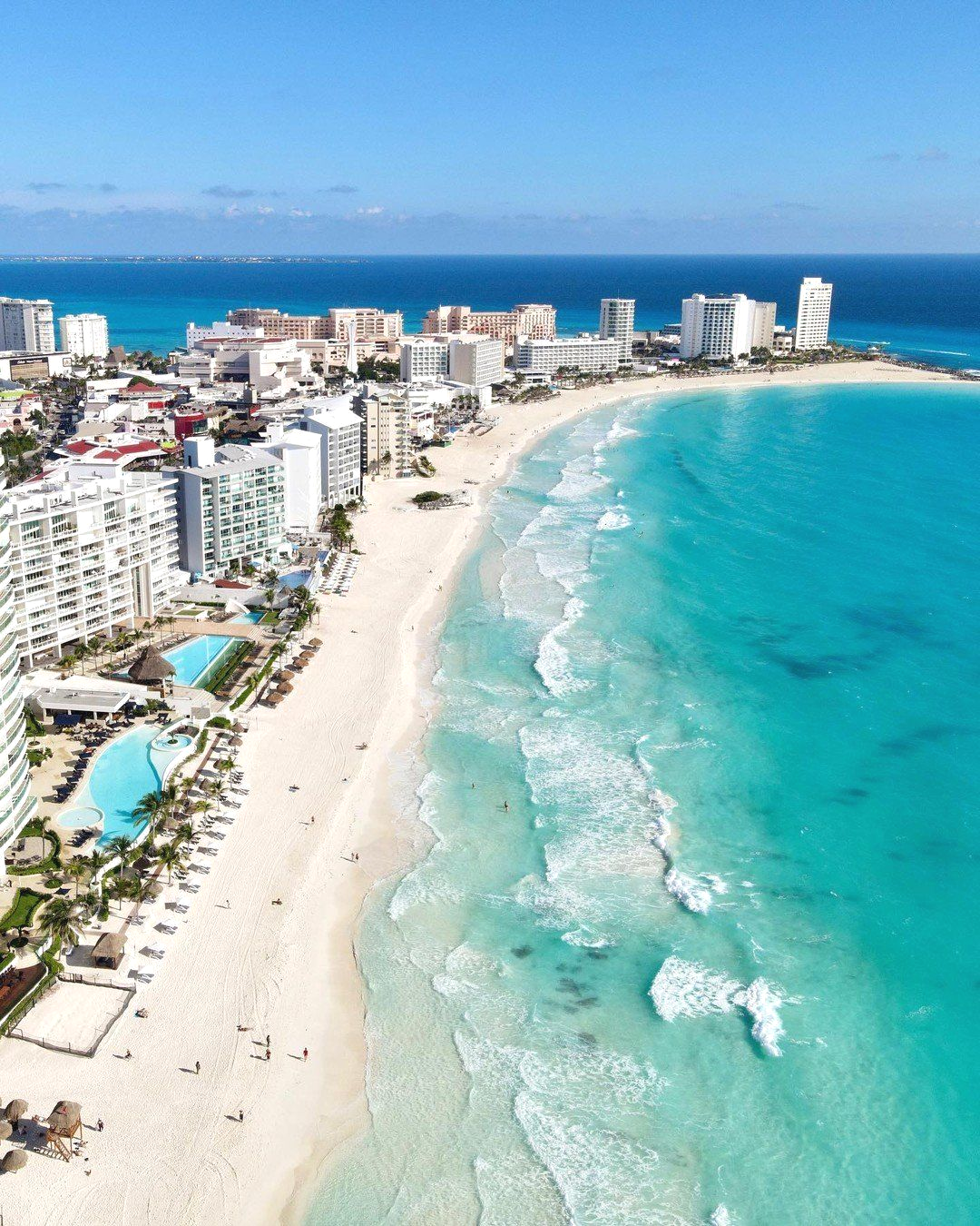 Una vista aérea de una playa con una ciudad al fondo.