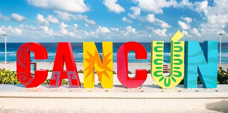 Un cartel colorido que dice cancún frente al mar.