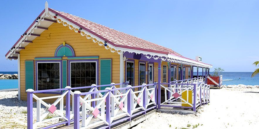Una casa amarilla y morada en una playa junto al océano