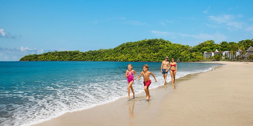 Una familia corre en la playa.