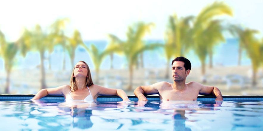 Un hombre y una mujer están sentados en una piscina.