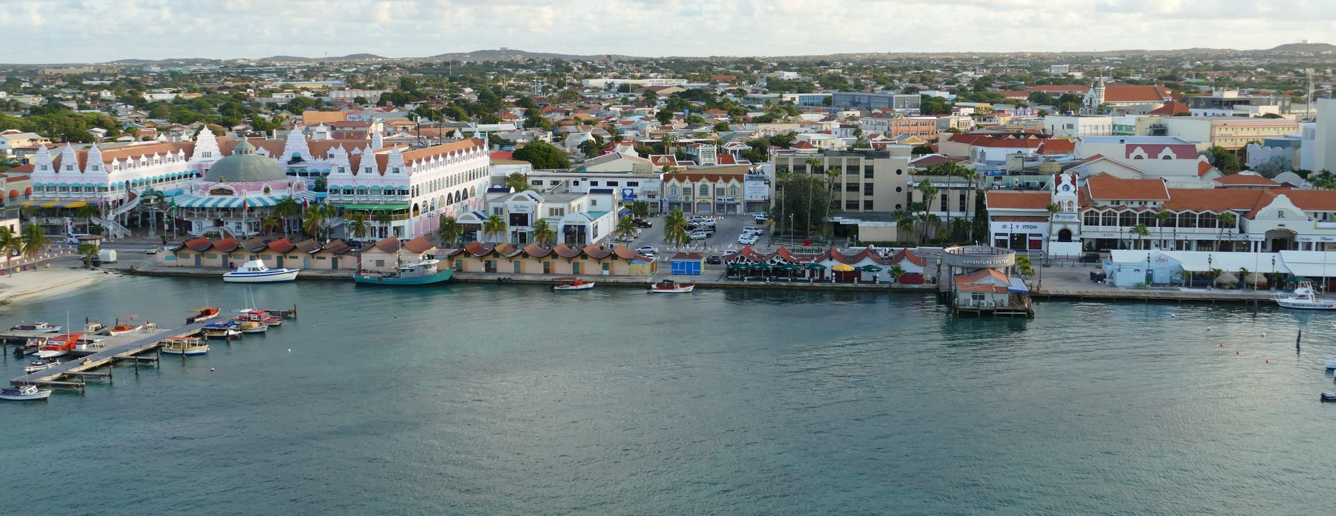 Un hombre y una mujer caminan por la playa tomados de la mano.