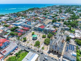 Un hombre y una mujer caminan por la playa tomados de la mano.