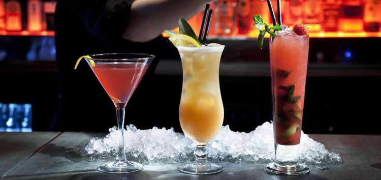 Un camarero sirve una bebida en una copa de martini.