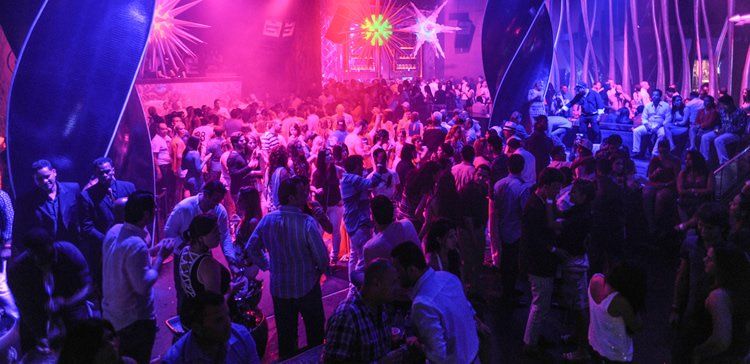 Un gran grupo de personas baila en una discoteca.
