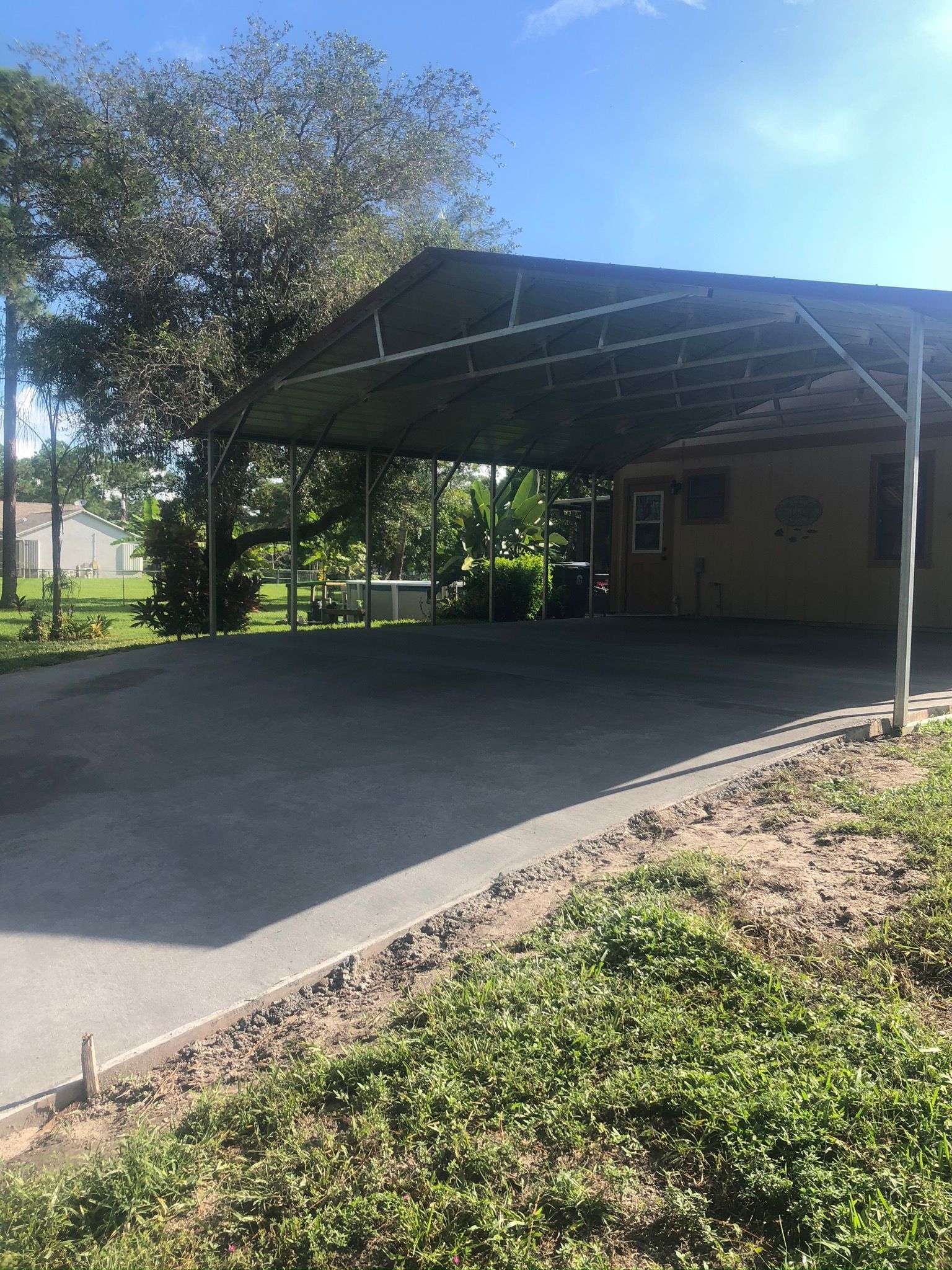 A carport with a canopy over it is next to a house.