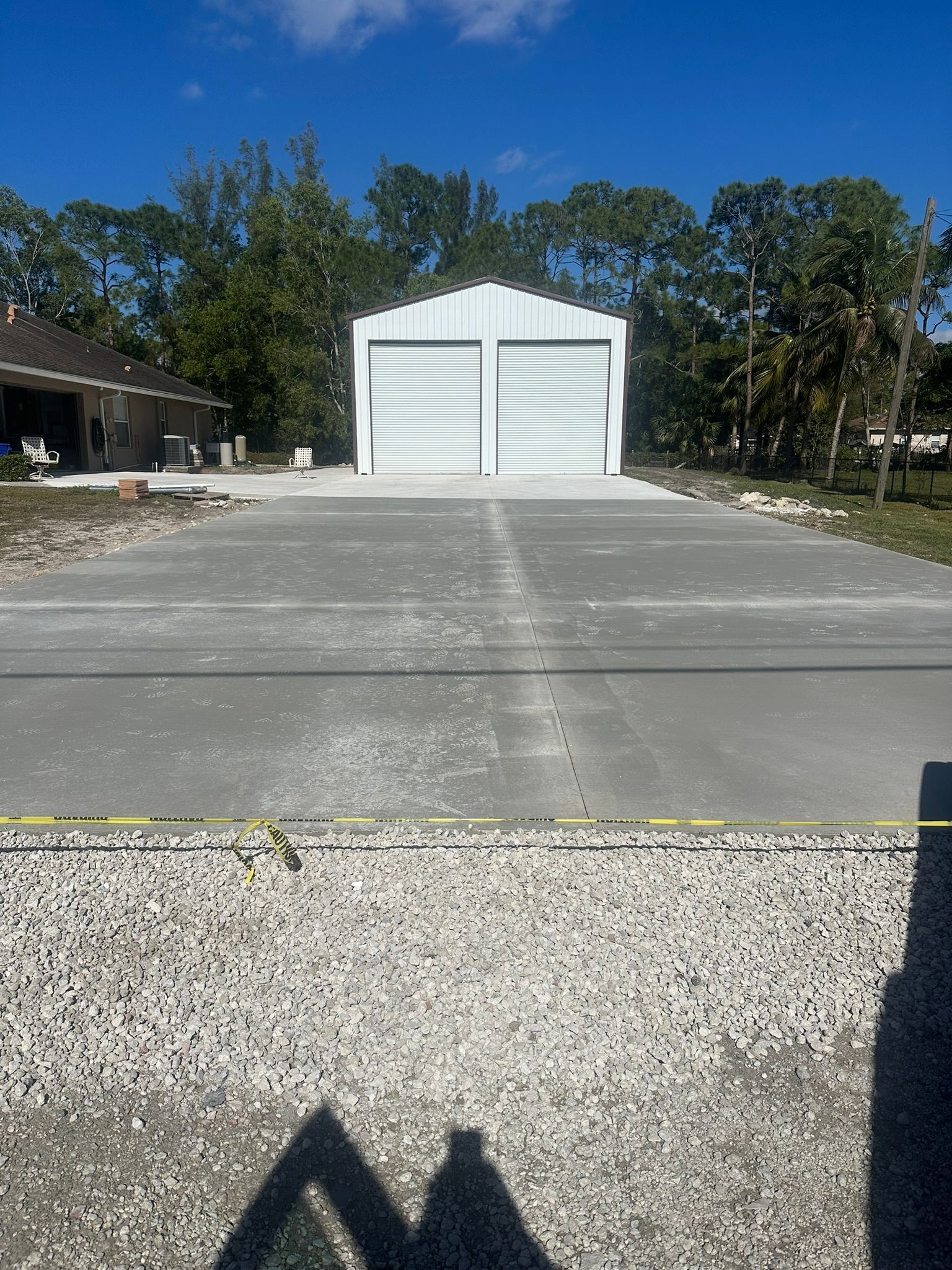 A concrete driveway with a white building in the background.