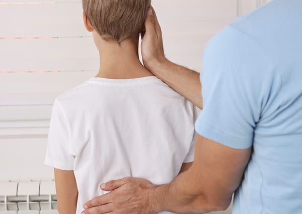 physiotherapist examining a teenager at our Cheltenham clinic