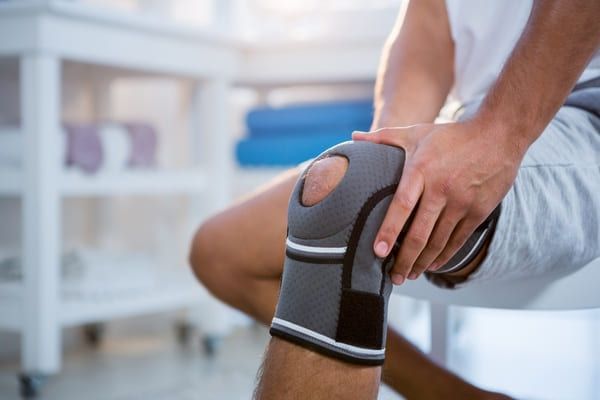 man with strapping for knee pain