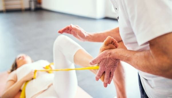 physiotherapist treating a woman patients knee