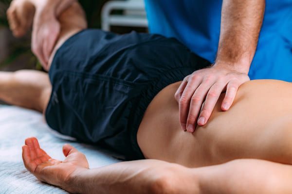 Physiotherapist-giving a man sciatica treatment in Cheltenham