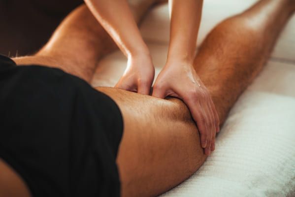 physiotherapist doing a sports massage treatment on the back of the knee
