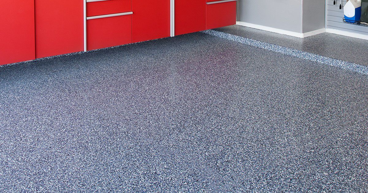 A kitchen with red cabinets and a gray floor.