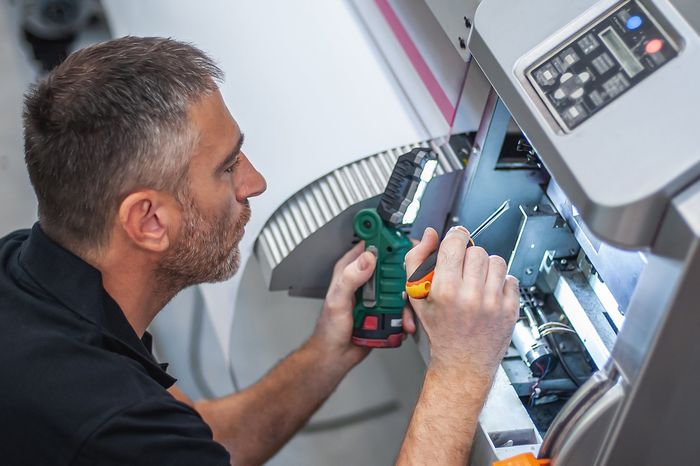 Professional Worker Repairing Offset Machine