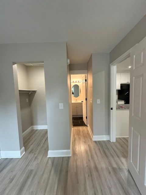 A hallway leading to a kitchen and a bathroom in a house.