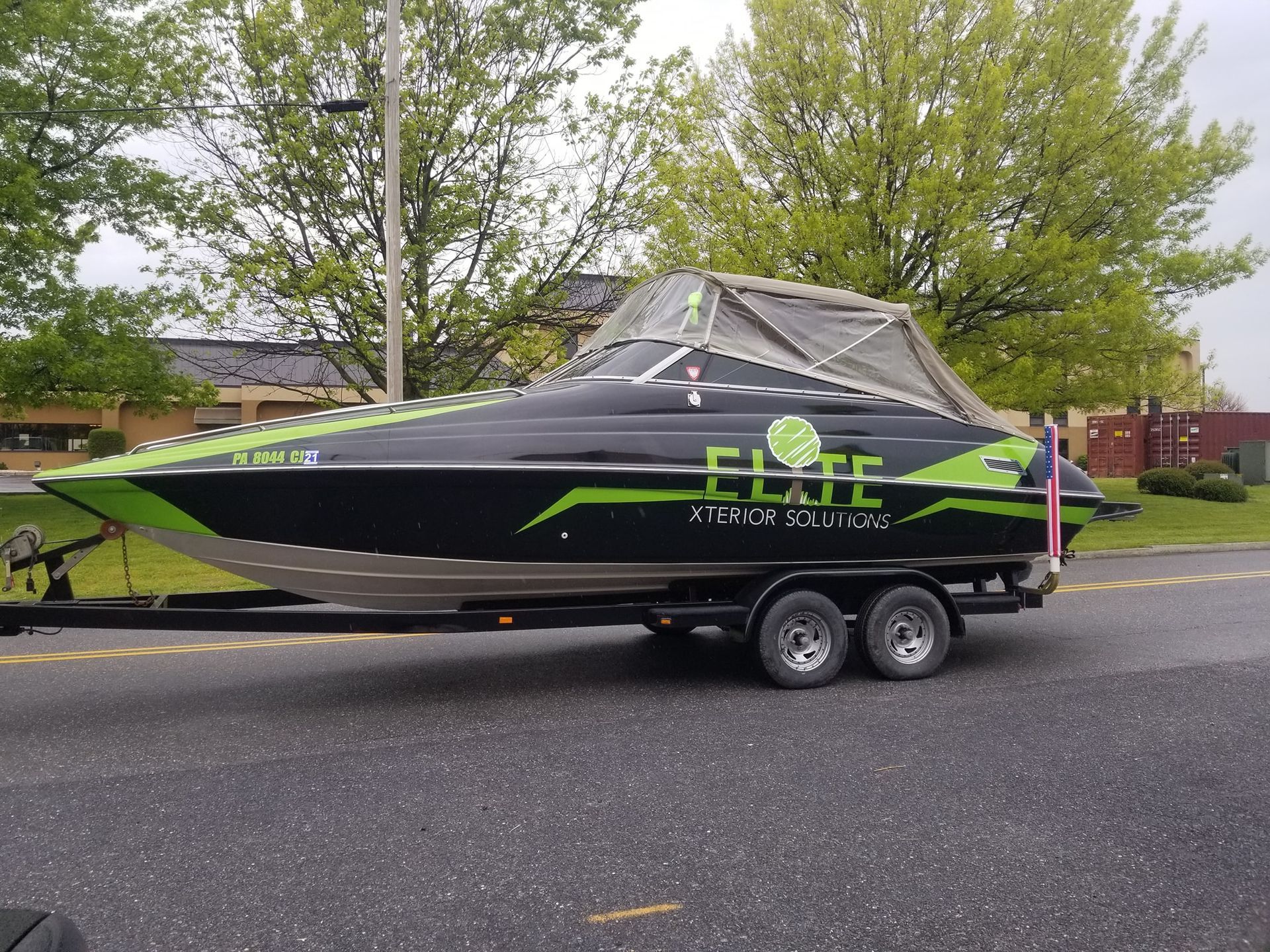 A white and black Yamaha jet boat on a trailer parked outside a building with a blue frame.