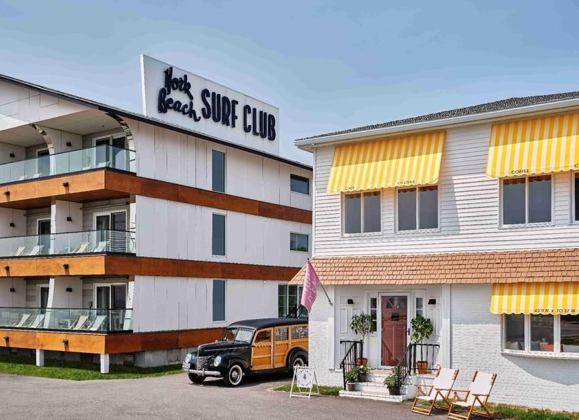 Ocean Surf at York Beach, a white hotel with wood accents, a yellow-awned building, and a vintage woody car parked in front.