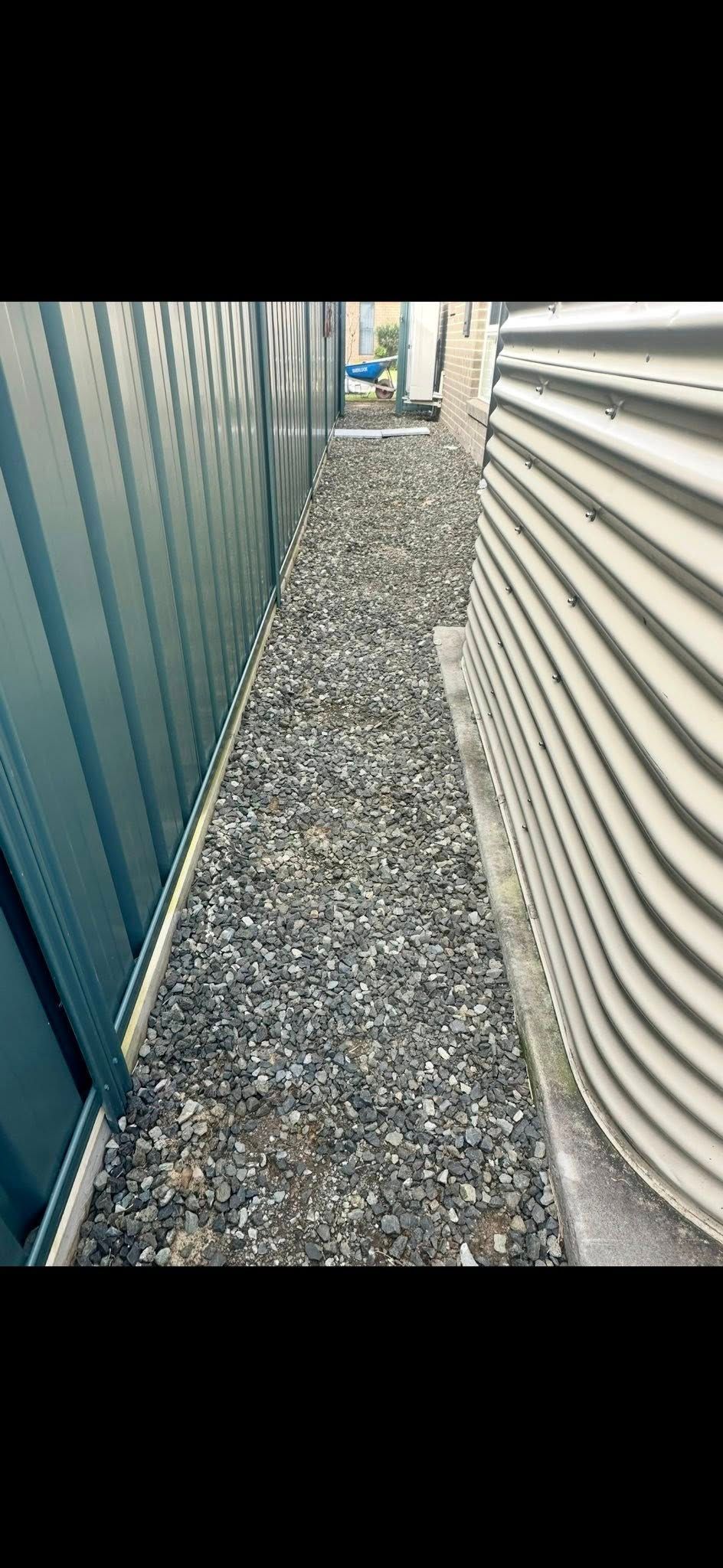 Narrow gravel pathway between corrugated walls. — East Coast Paving in Medowie, NSW