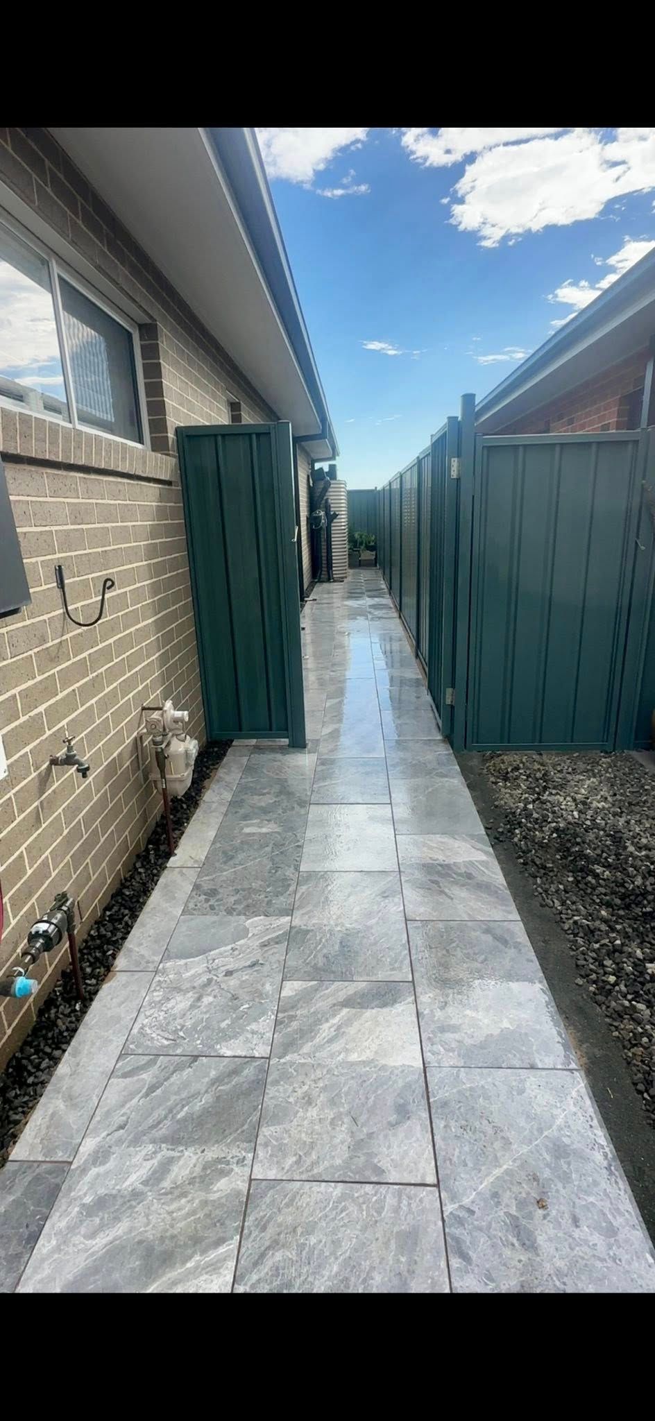 A Narrow Paved Walkway Between Buildings, Bordered by a Fence — East Coast Paving in Maitland, NSW