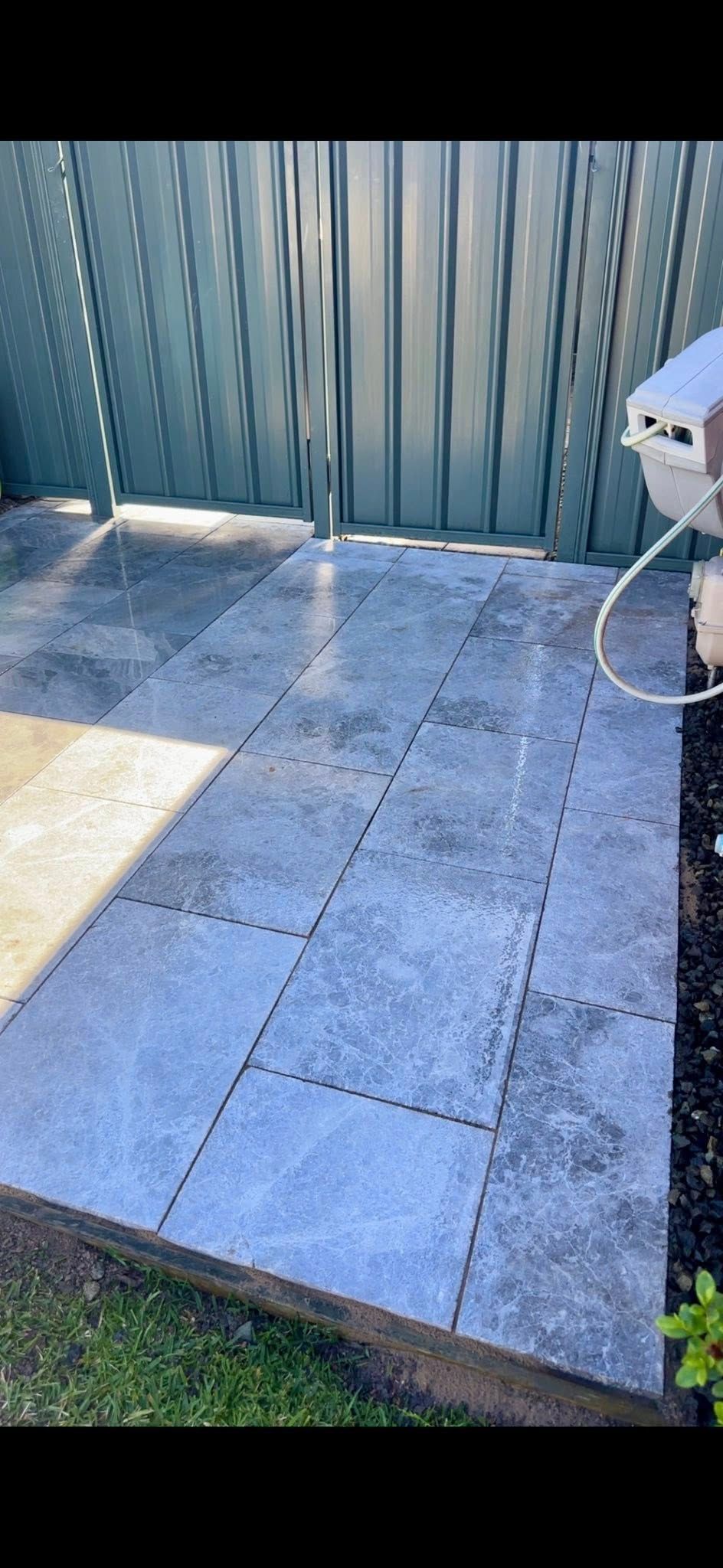 Paved walkway leading to a metal fence; sunlight casts shadows on the paving stone — East Coast Paving in Seaham, NSW