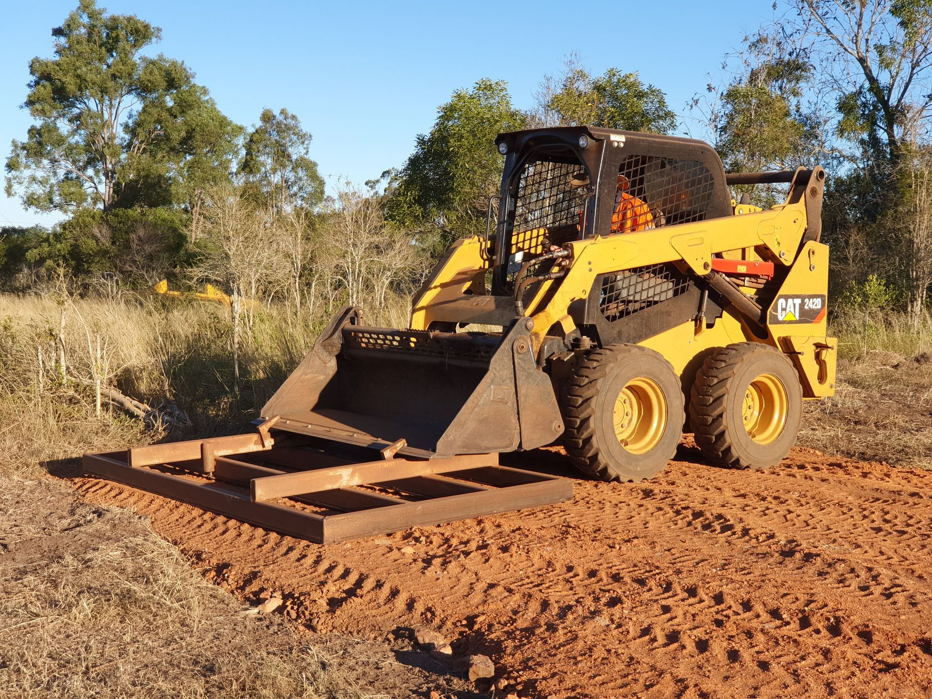 A Bulldozer Is Driving Through A Dirt Field — Greenslade's Dozer & Excavator Hire Pty Ltd In Taabinga, QLD