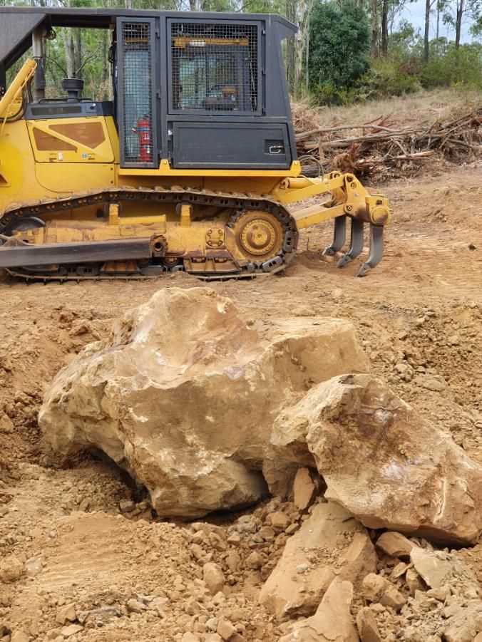 Dozer Clearing The Ground With Large Rock In Front — Greenslade's Dozer & Excavator Hire Pty Ltd In Nanango, QLD