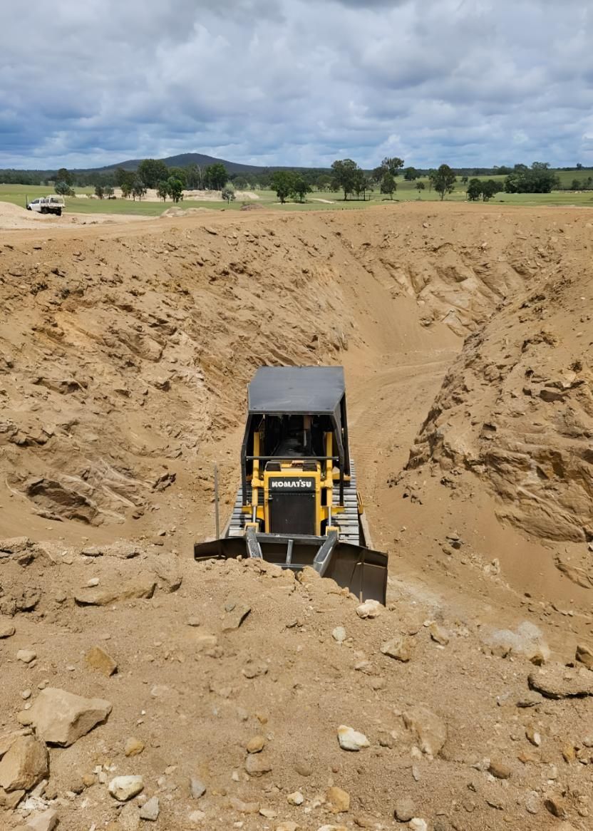 A Toy Bulldozer Is Driving Through A Dirt Field — Greenslade's Dozer & Excavator Hire Pty Ltd In Durong, QLD