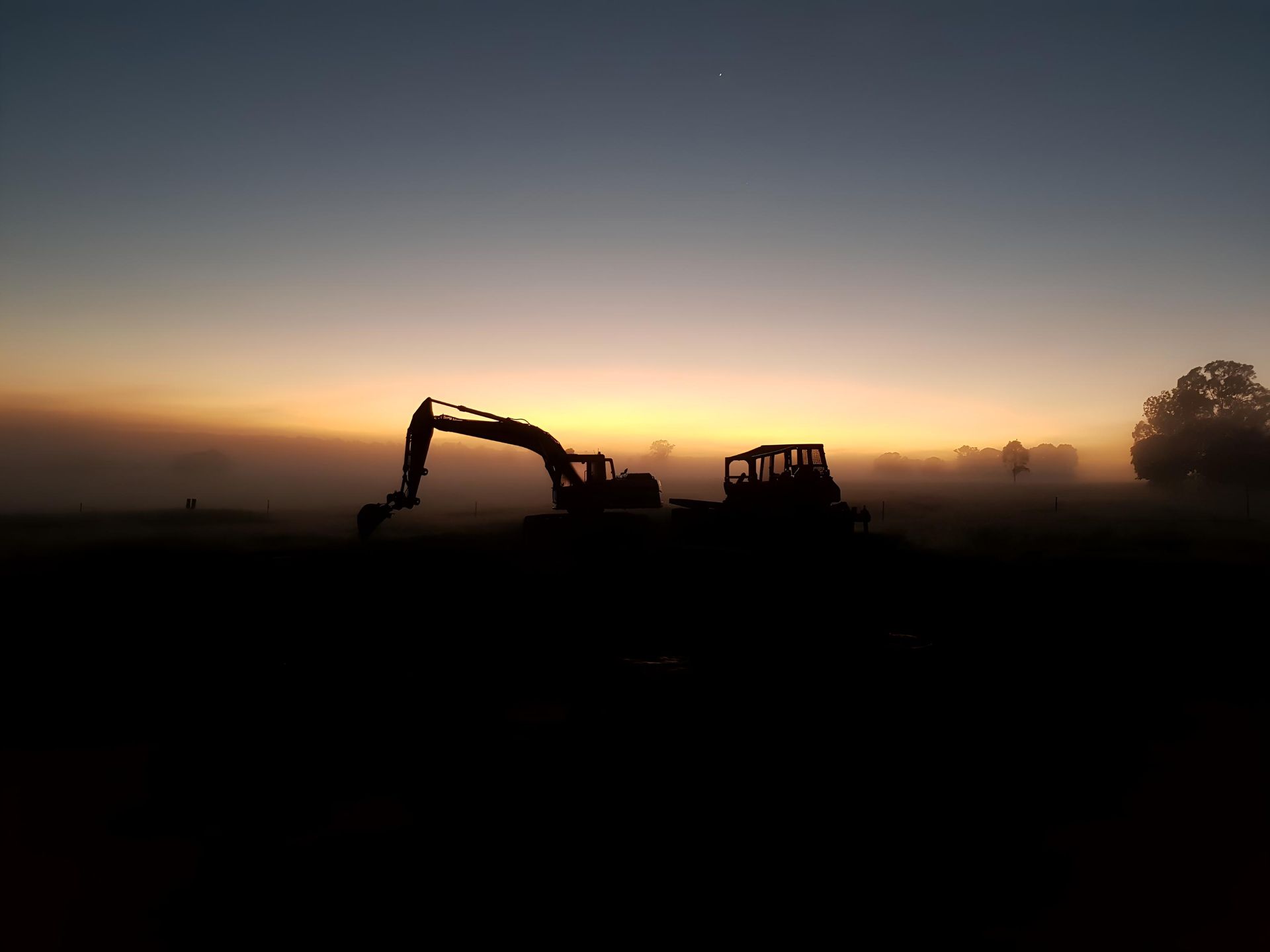 A Tractor Is Silhouetted — Greenslade's Dozer & Excavator Hire Pty Ltd In Kumbia, QLD