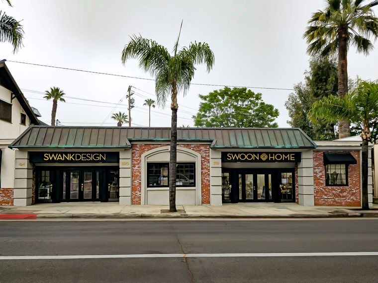 Street-front storefronts in Redlands, CA painted by Dunnrite Painting with dark awnings and palm trees along a quiet road