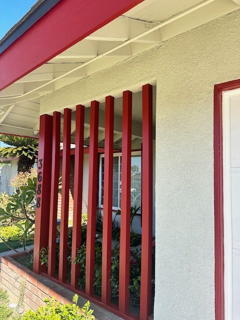 A white house with red bars on the front