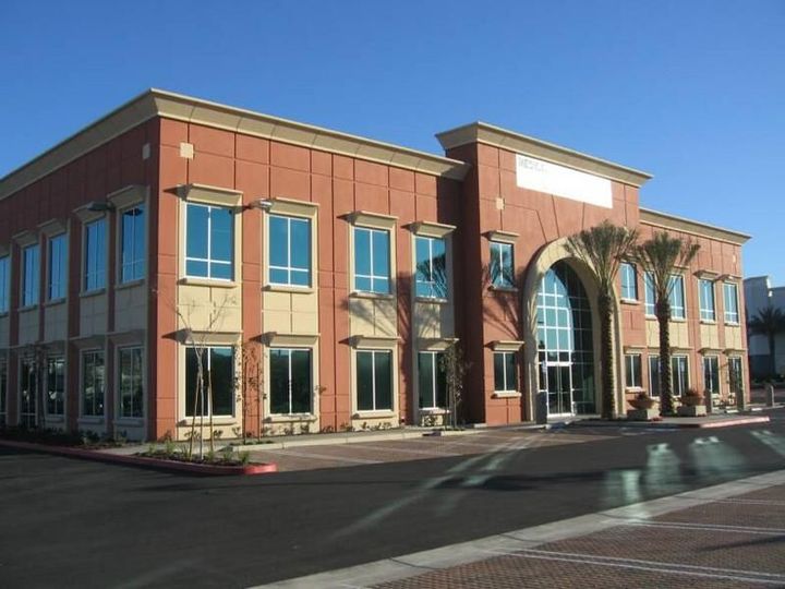 A large brick building with a palm tree in front of it