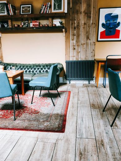 A living room with a couch , chairs , tables and a radiator.