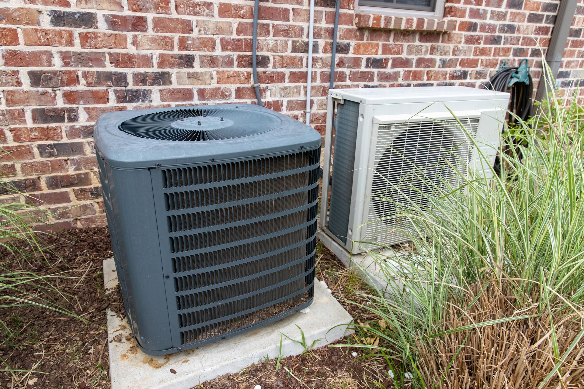 A white air conditioner is hanging on a wall next to a window.