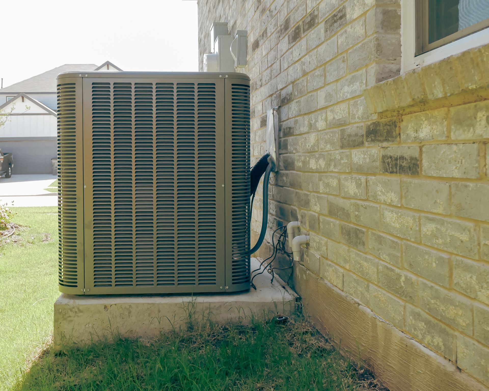 Air conditioning unit next to a brick wall.
