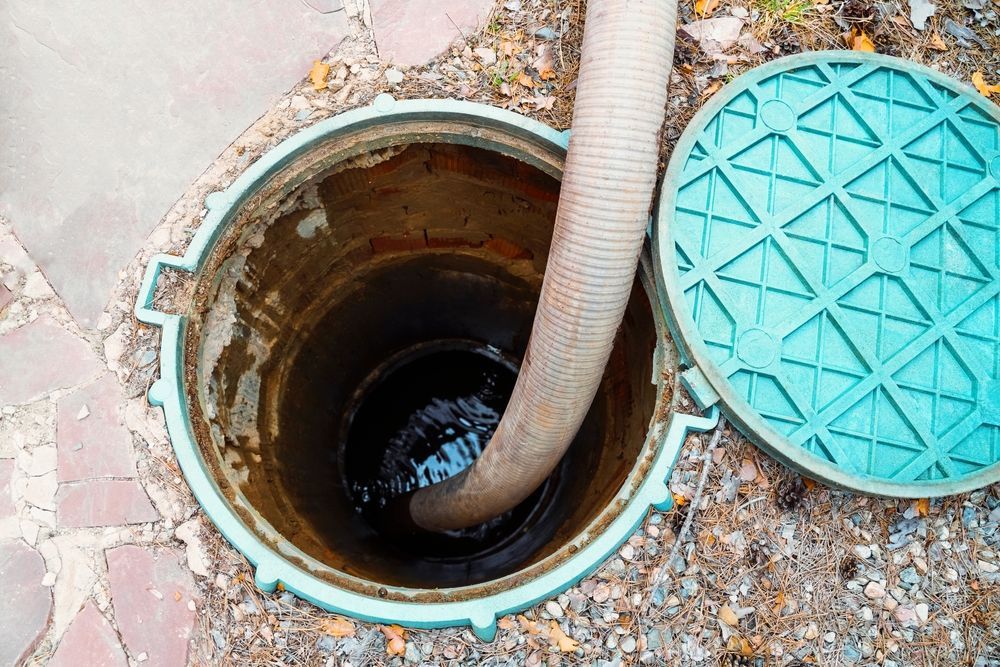 Open Septic Tank With a Hose Inside, Being Pumped — Raptor Waste Management In Pimpama, QLD