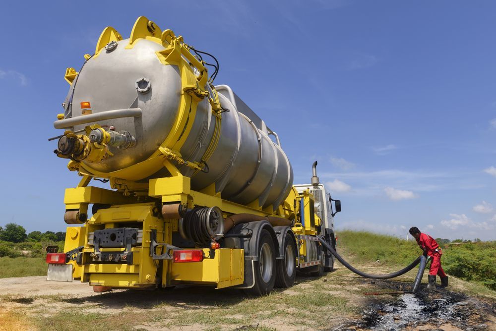 A Yellow and Silver Vacuum Truck is Extracting Waste — Raptor Waste Management In Carrara, QLD