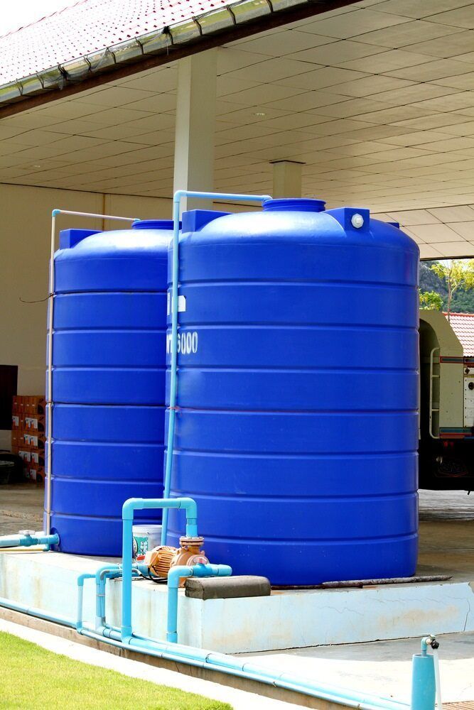 Two Large Blue Water Storage Tanks Outdoors — Raptor Waste Management In Terranora, NSW
