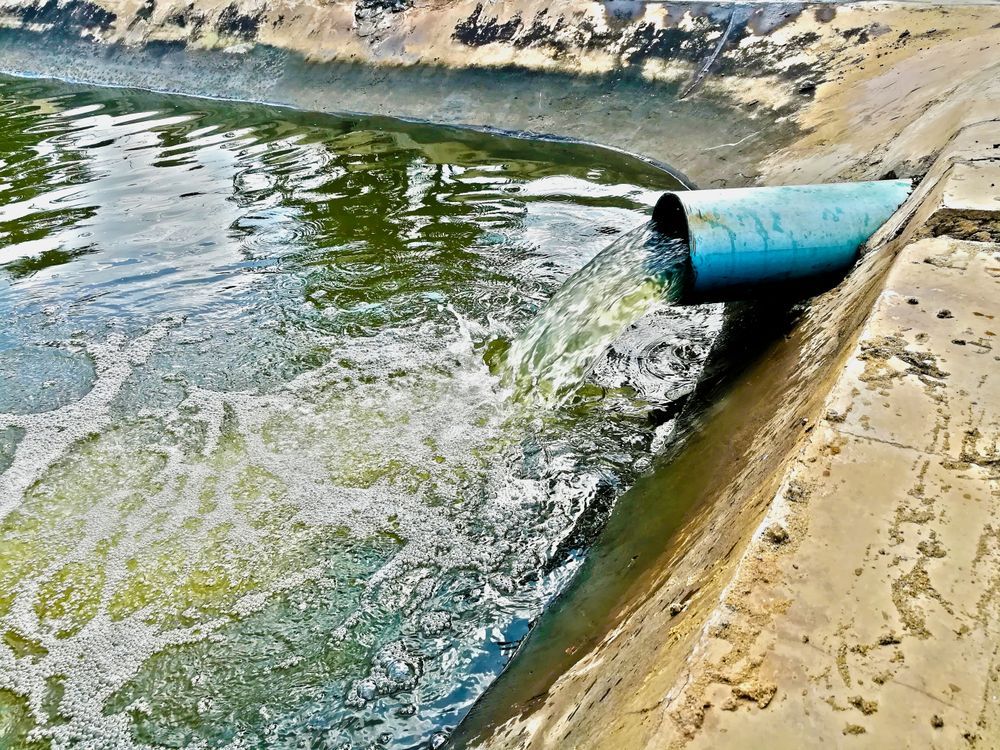 Pipe Pouring Murky Water Into a Concrete Basin — Raptor Waste Management in Coolangatta, QLD