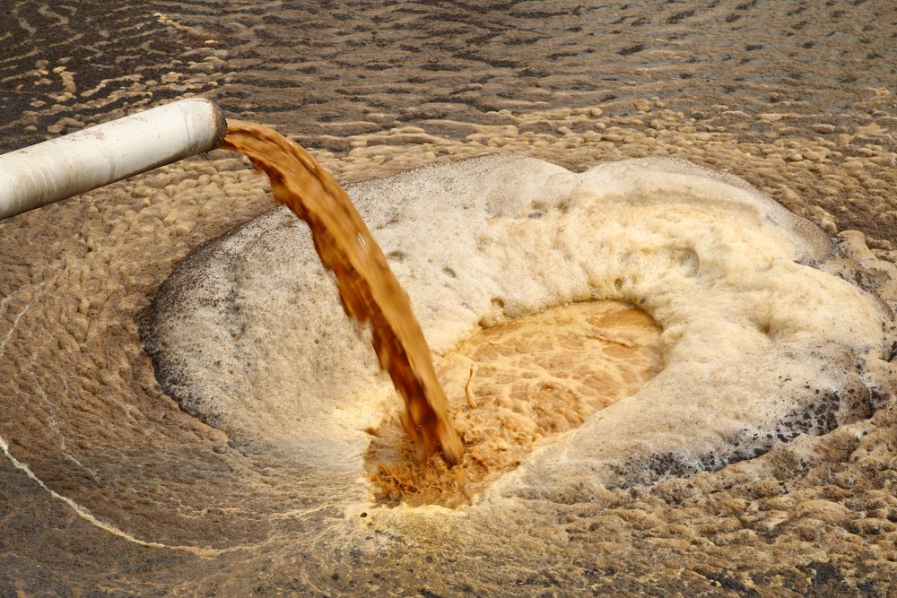 Brown Liquid Pouring From a White Pipe — Raptor Waste Management In Uki, NSW