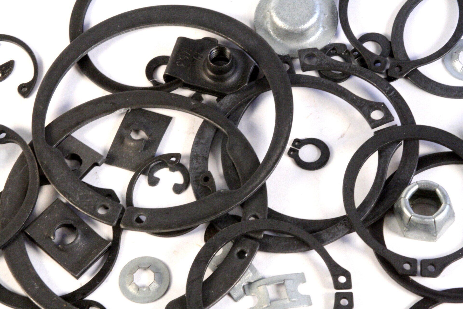 A pile of metal rings and nuts on a white surface