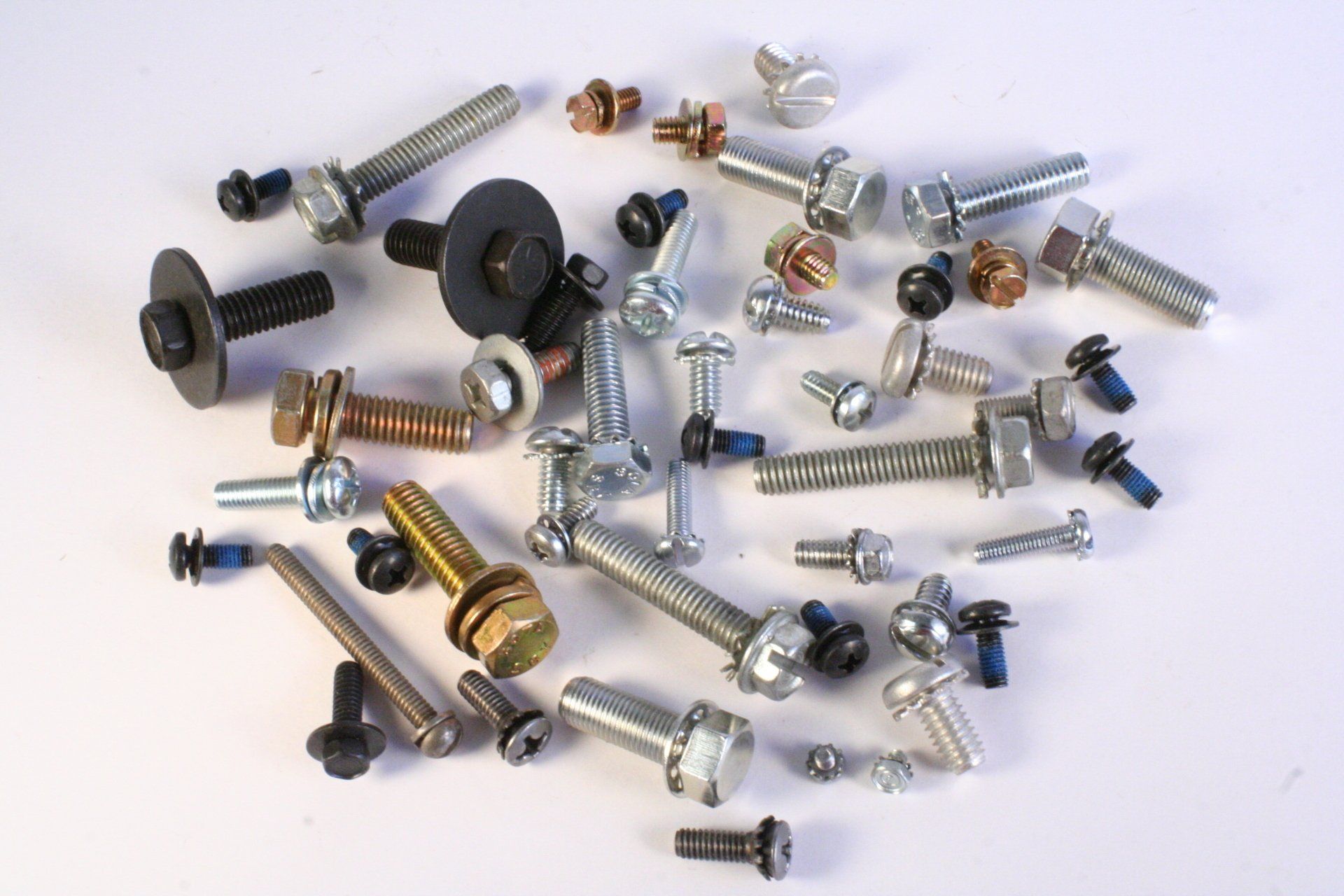 A bunch of screws and bolts on a white surface